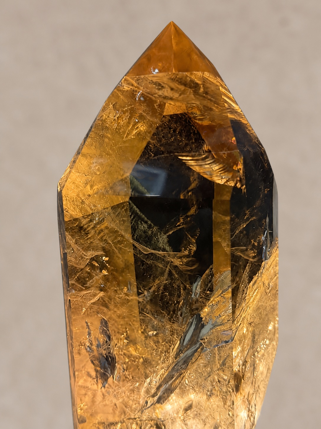 Close detail of the warm-toned quartz point and internal formations